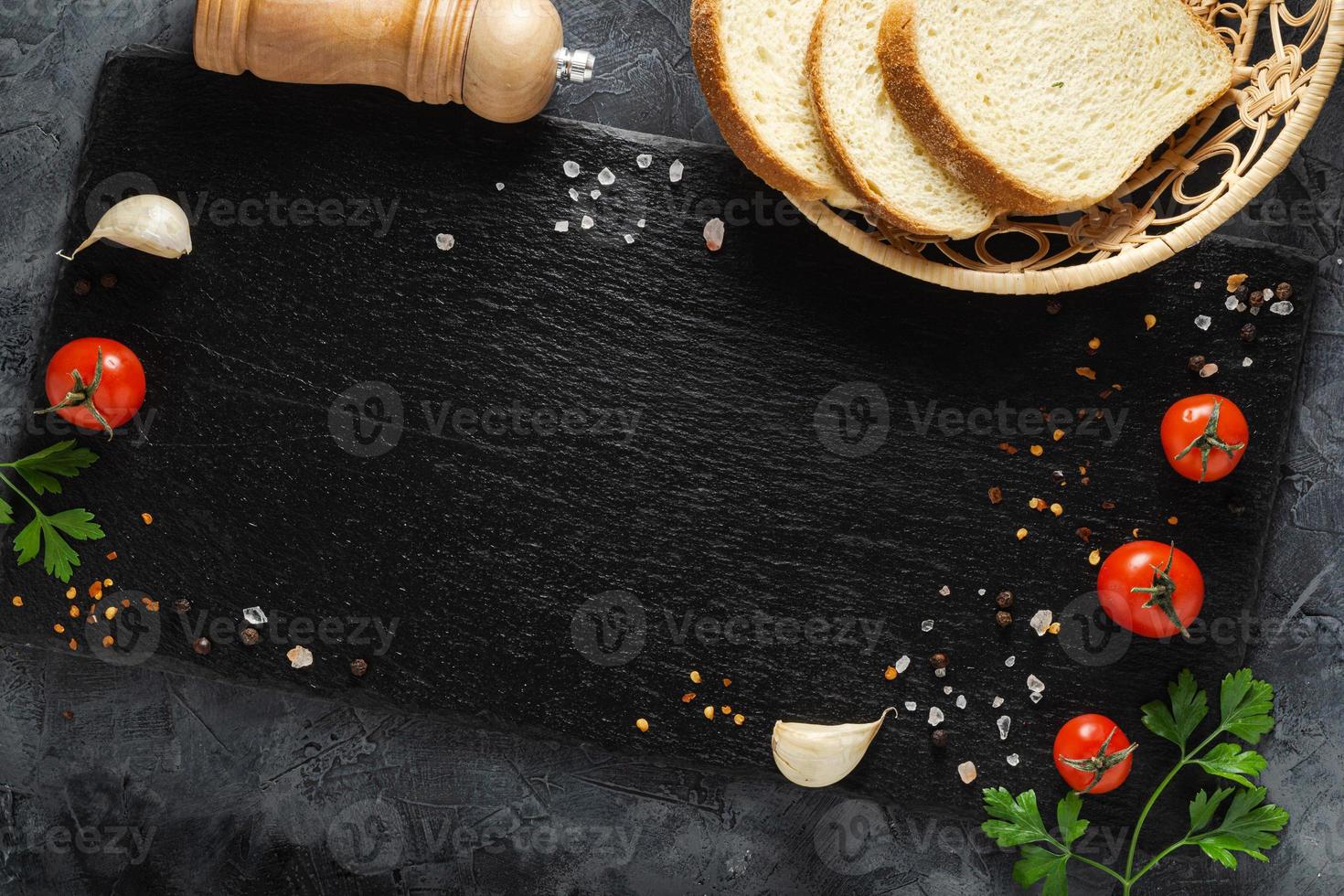 Bread with vegetables on slate board. Copy space. Top view. photo