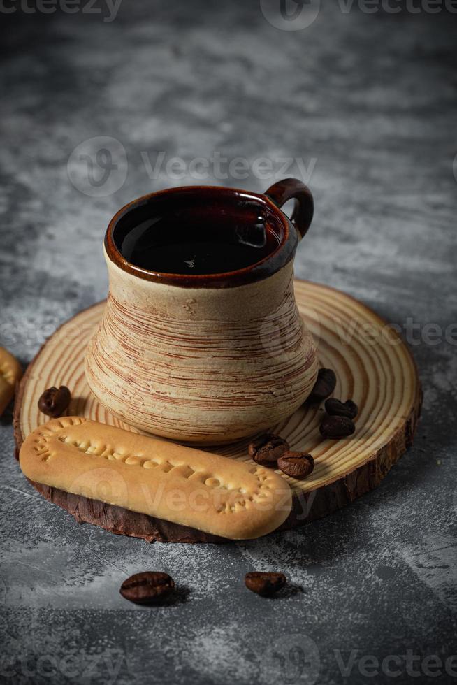 Coffee in a clay cup and cookies on an abstract background photo