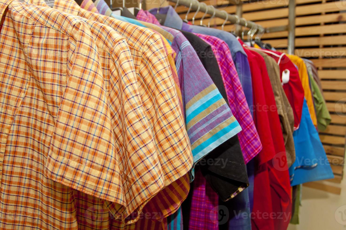 t camisa y panjabis son colgando en ropa perchas en un monitor tienda. foto