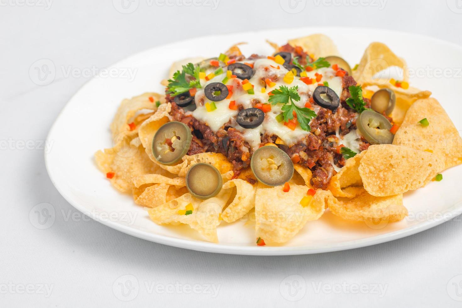 Mexican Famous Food Spicy Ground Beef Nachos. Heated crunchy tortilla chips with melted cheese and jalapeno served a snack food. photo