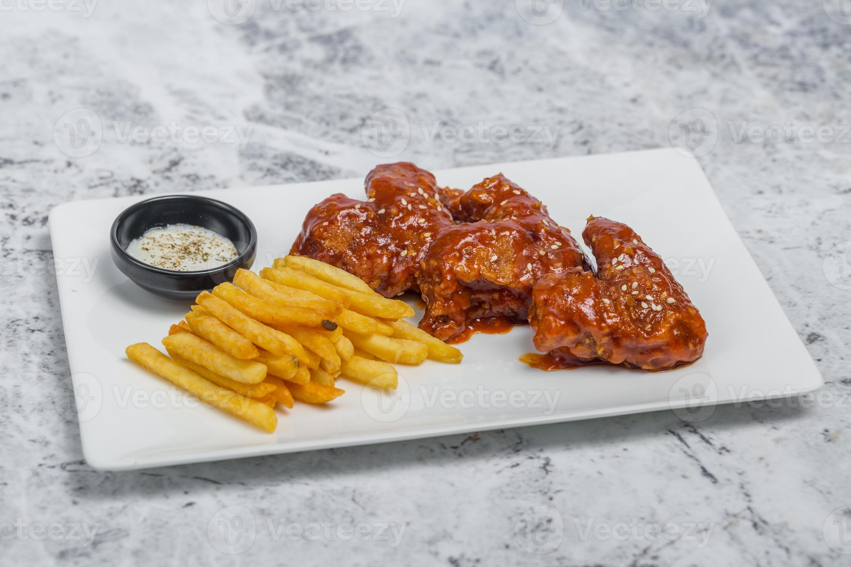 Hot and spicy buffalo chicken wings and crispy french fries with white