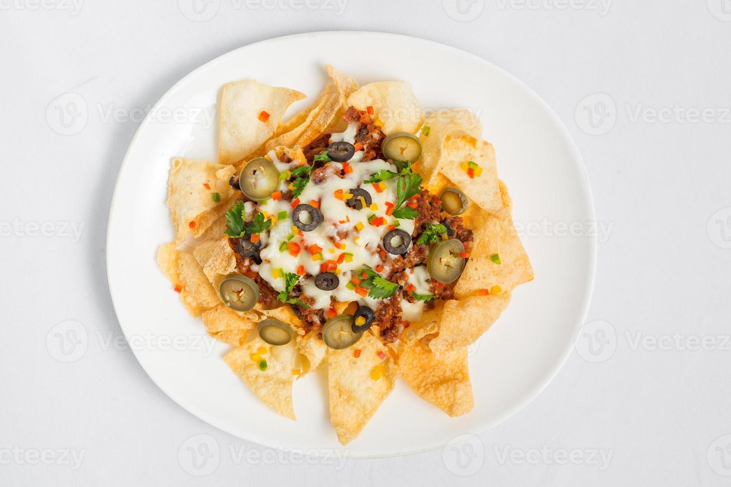 Mexican Famous Food Spicy Ground Beef Nachos. Heated crunchy tortilla chips with melted cheese and jalapeno served a snack food. photo