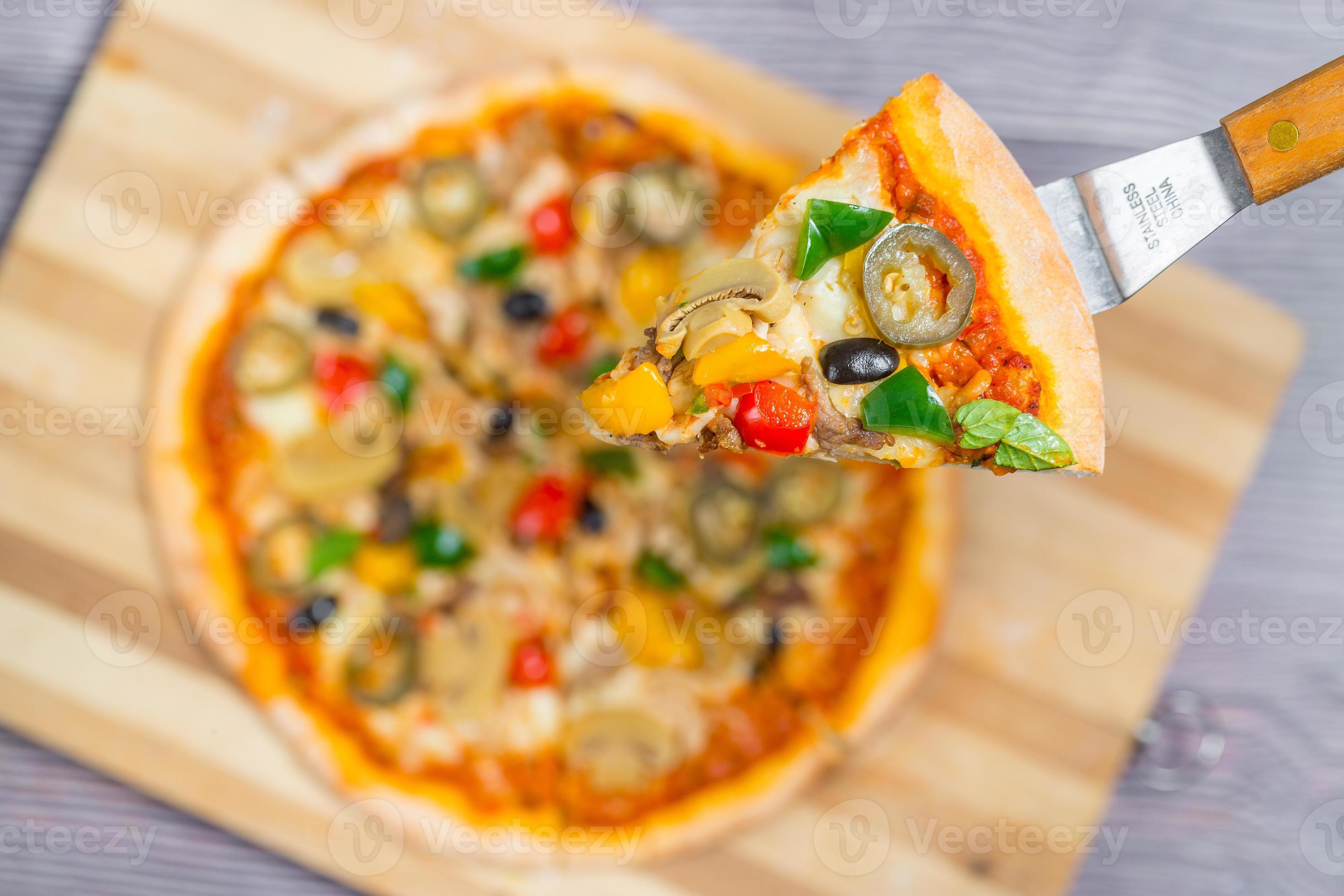 Close up and top view of Chicken mushroom jalapeno pizza slice lifted