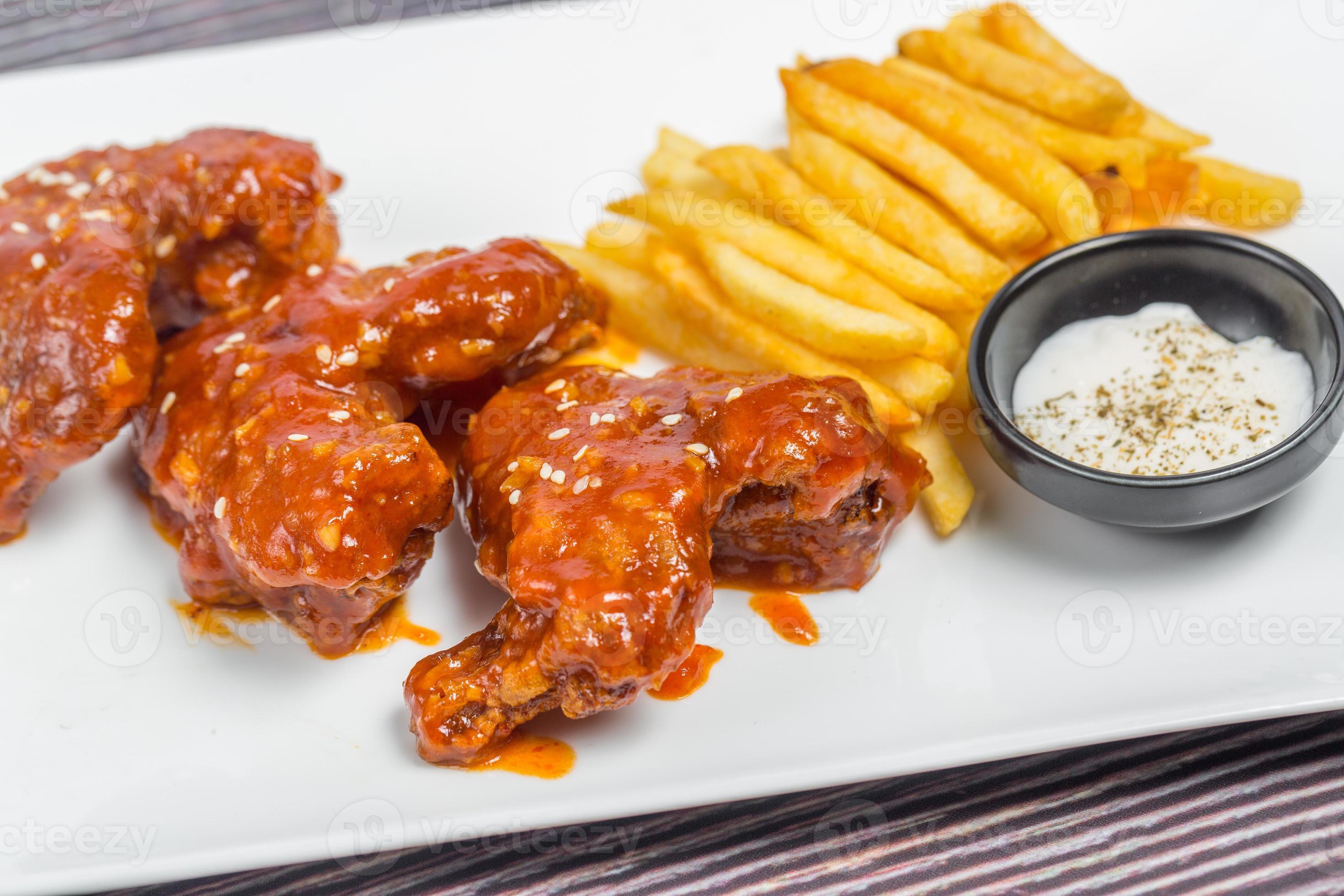 Hot and spicy buffalo chicken wings and crispy french fries with white