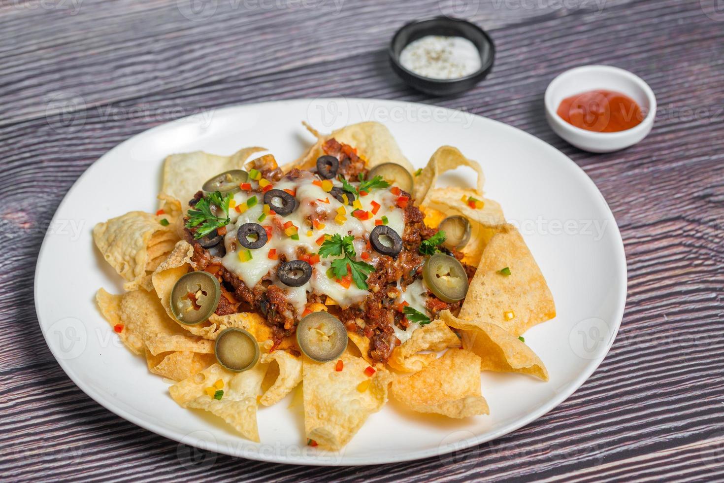 Mexican Famous Food Spicy Ground Beef Nachos. Heated crunchy tortilla chips with melted cheese and jalapeno served a snack food. photo