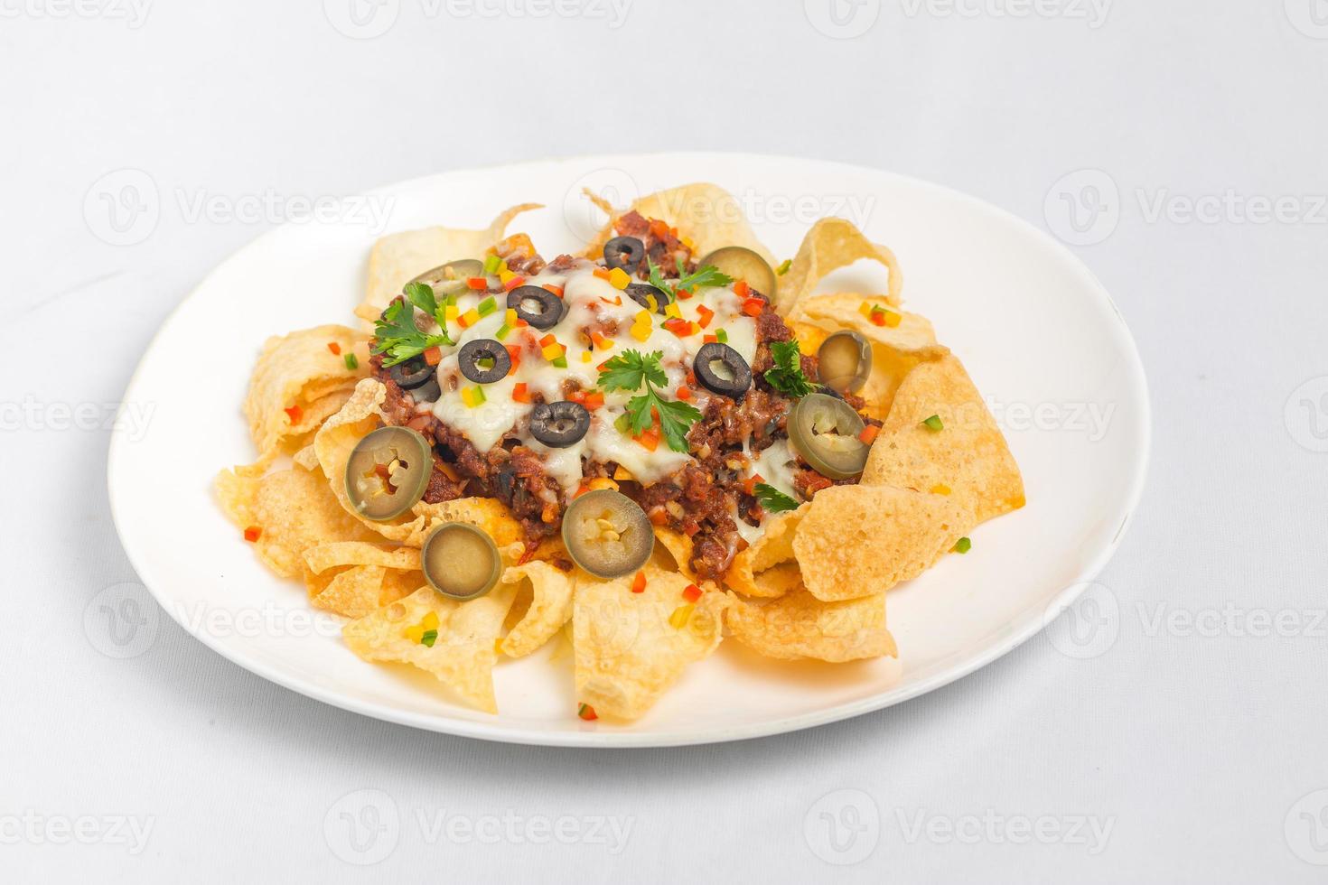 Mexican Famous Food Spicy Ground Beef Nachos. Heated crunchy tortilla chips with melted cheese and jalapeno served a snack food. photo