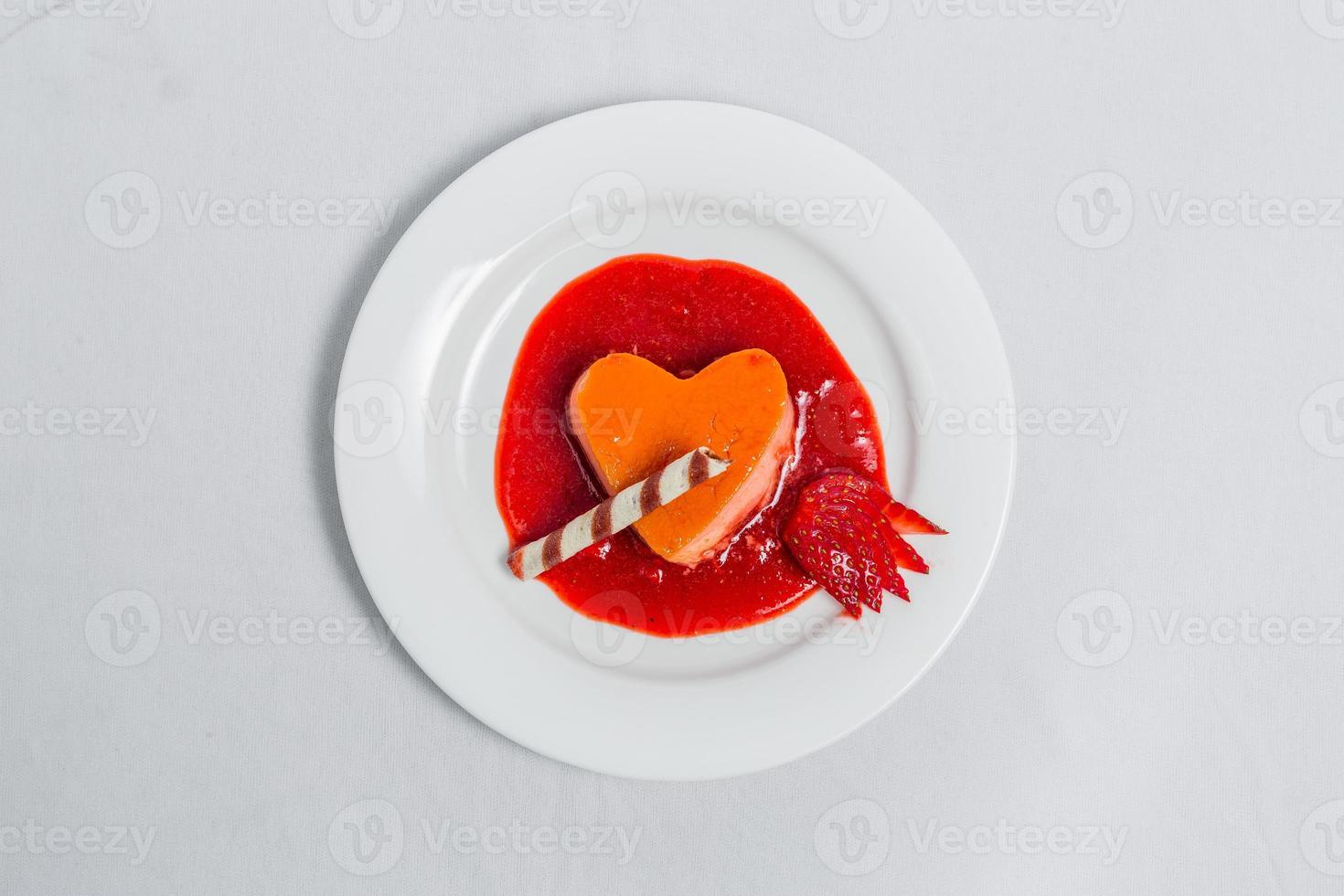 corazón conformado pudín con fresa salsa y oblea. san valentin postre receta. foto