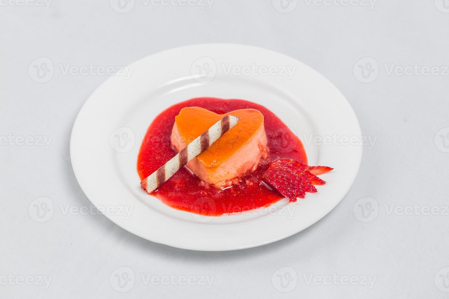 Heart shaped pudding with strawberry sauce and wafer. Valentines dessert recipe. photo