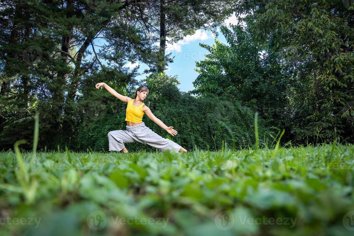 mujer practicando qi gong Tai chí ángulo a suelo nivel, selectivo enfocar. foto