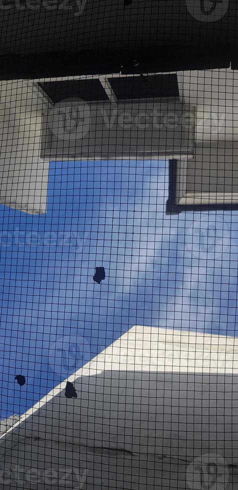 The background photo of the sky which has wire mesh and white houses. V