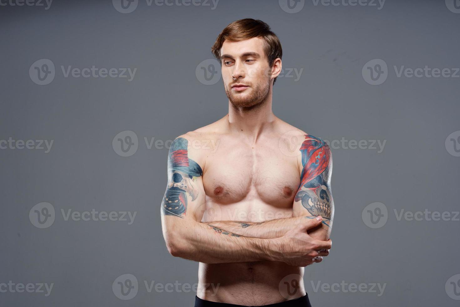 sport man cropped view workout tattoo on arms gray background photo