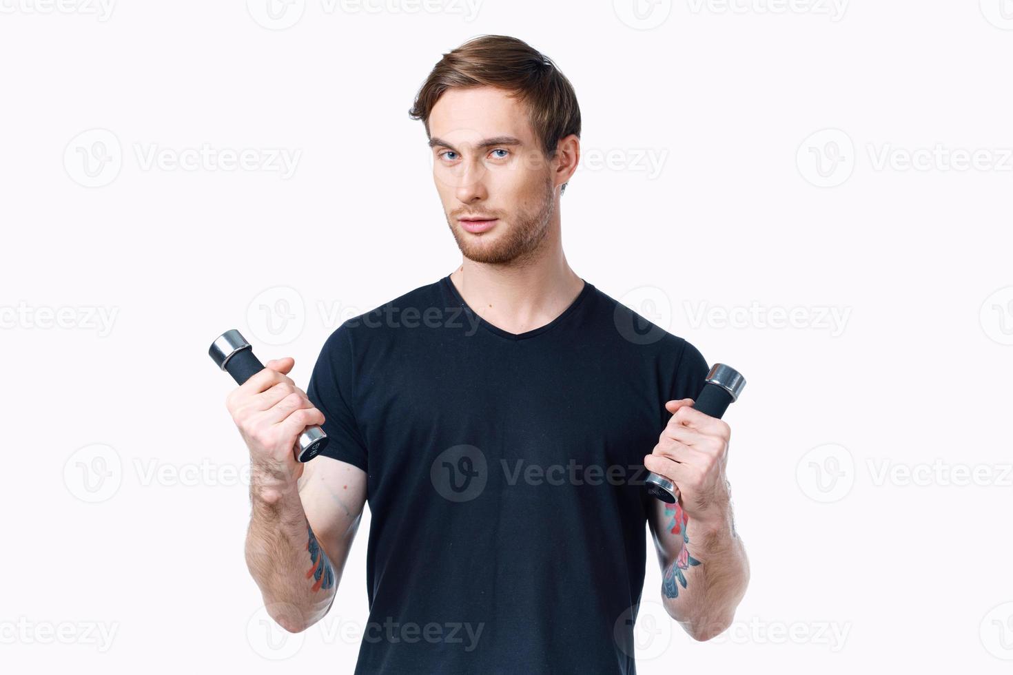 male athlete with dumbbells in hands on a light background cropped view photo