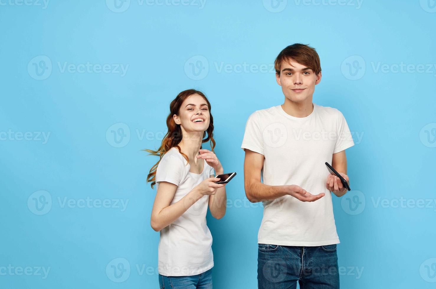 cheerful young couple in white t-shirts phones in hands communication lifestyle photo