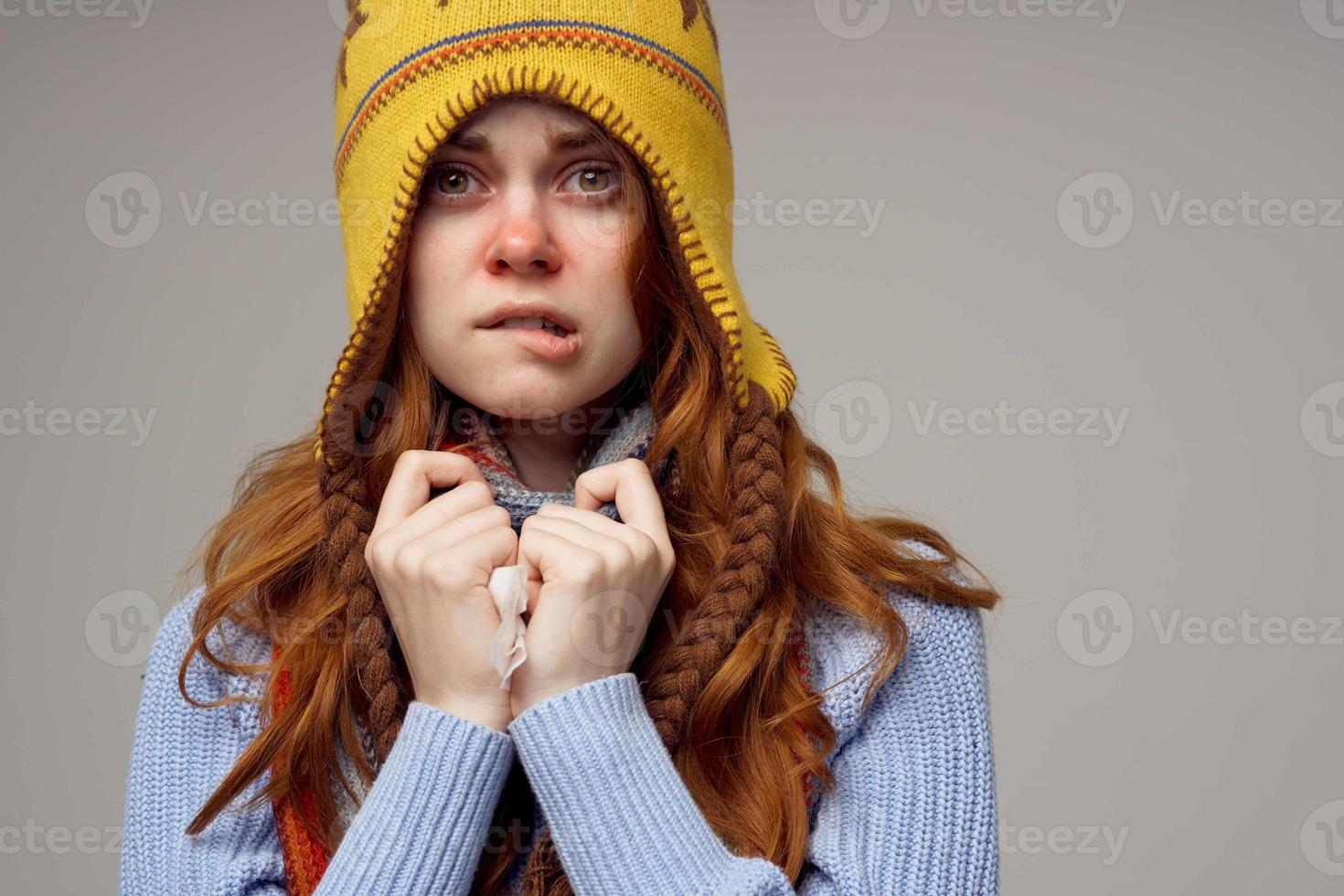 red-haired woman neck scarf with a hat on his head light background photo