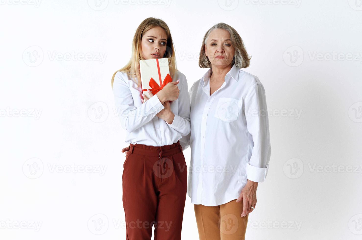Mom and daughter are standing next to a gift holiday emotions photo