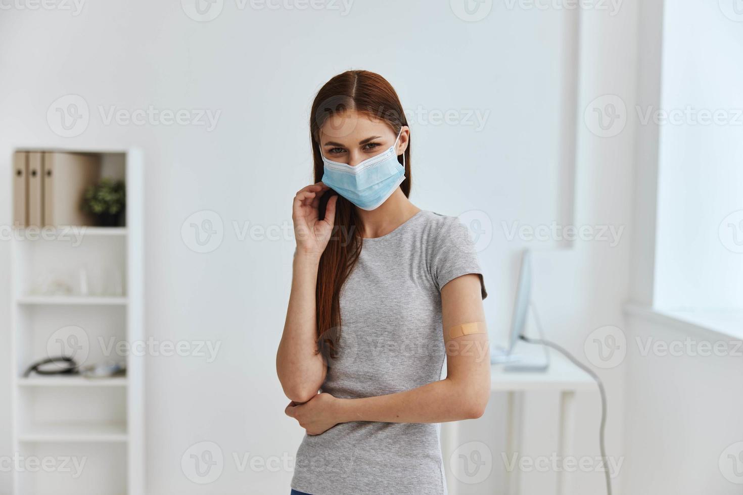 germicidal plaster on the shoulder of a woman wearing a medical mask in a hospital covid passport photo