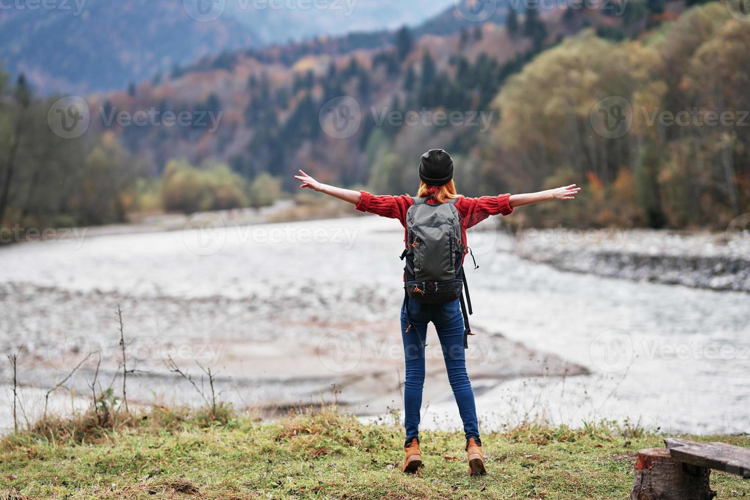 woman hiker with backpack near river mountains landscape freedom photo