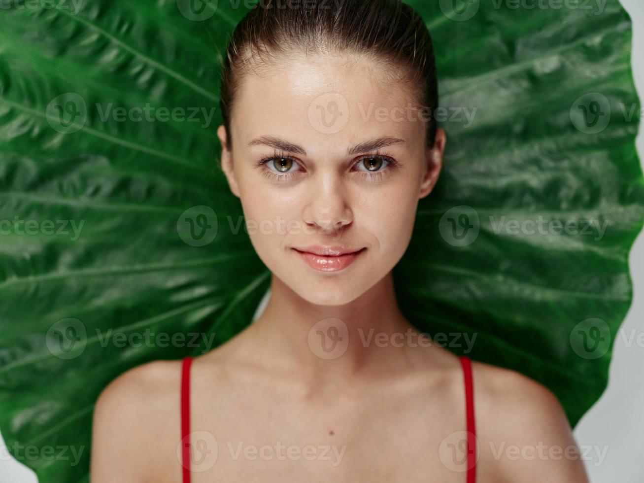 pretty woman with bare shoulders with palm behind her back exotic cropped view photo