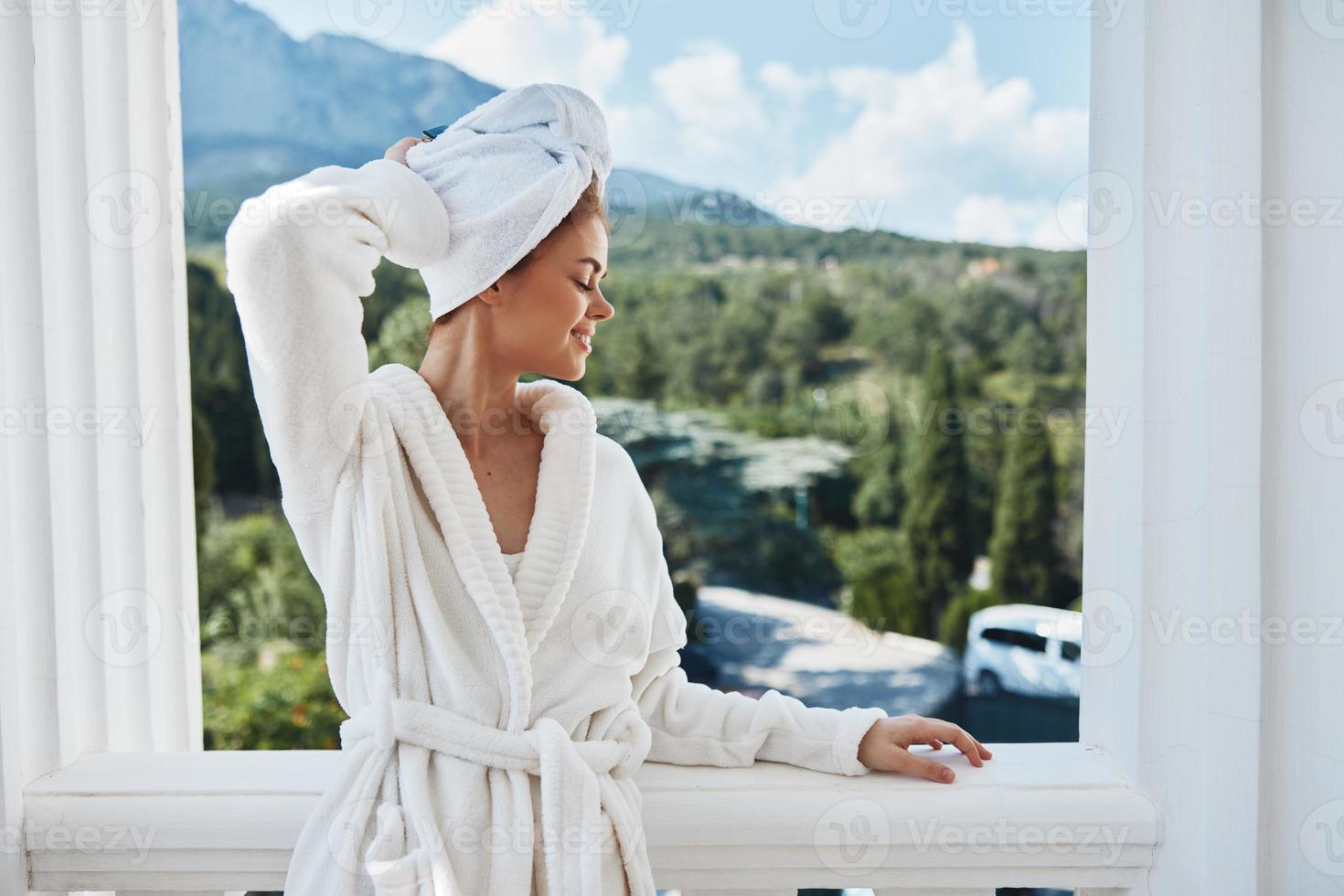 mujer en un blanco túnica en el balcón poco en verde naturaleza Perfecto soleado Mañana foto