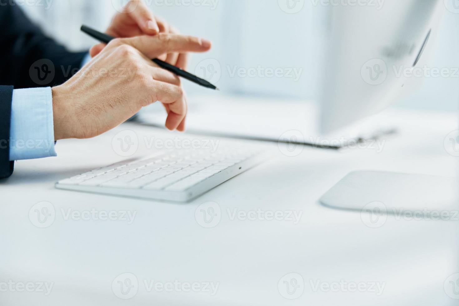 a man with a keyboard on a desktop office working at a computer photo