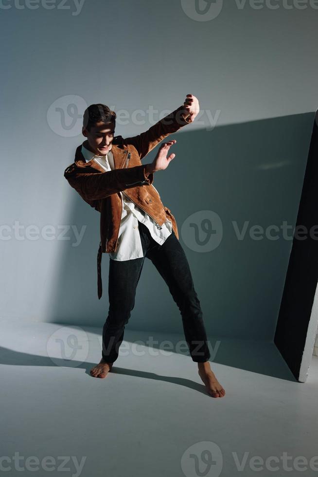 a man stands on an inclined floor indoors and covers himself with his hands from the sun photo