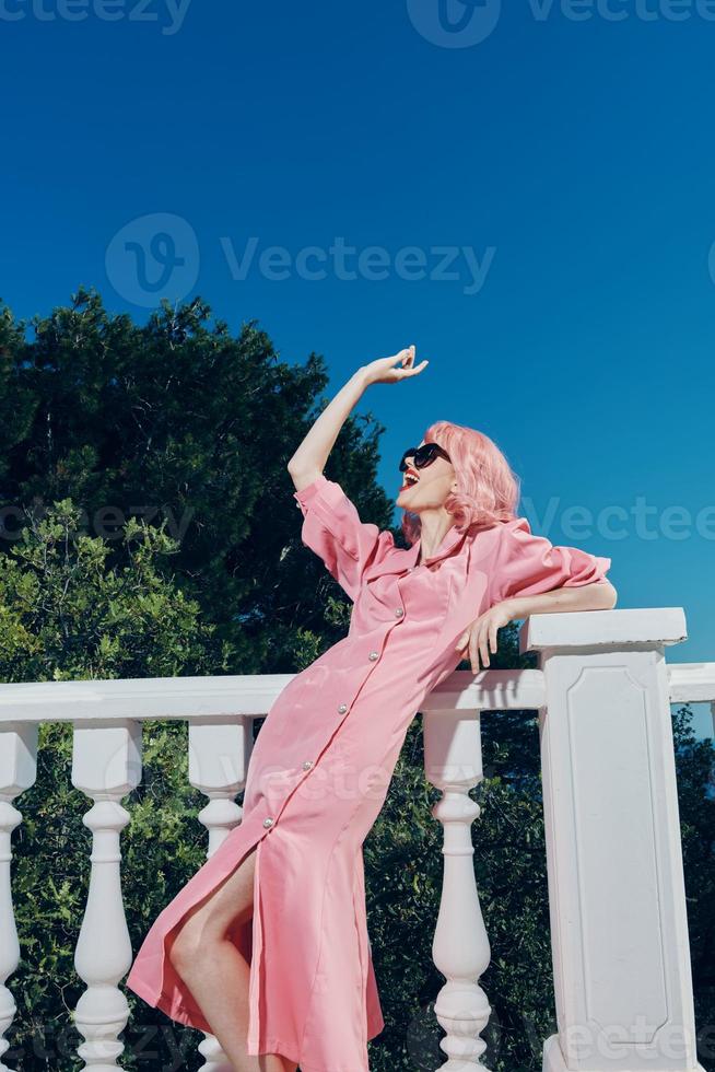 attractive woman with pink hair wearing sunglasses posing sunny day photo