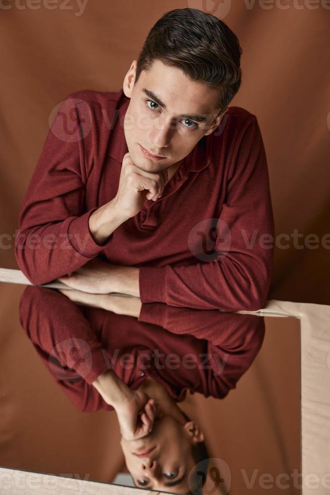 Reflection of a man in the mirror and brown shirt model fabric background photo