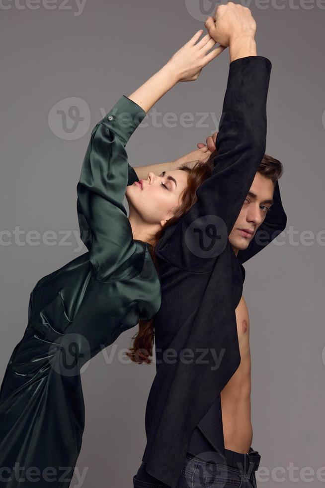 man and emotional woman on a gray background are gesturing with their hands photo