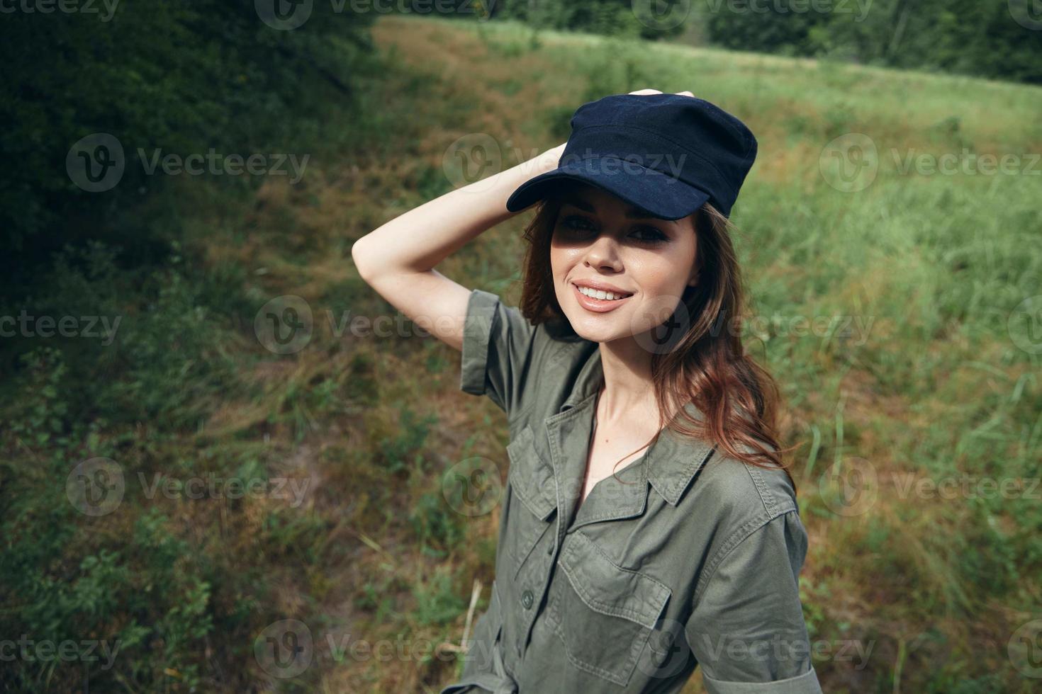 mujer en el bosque sonrisa Mira adelante verde mono negro gorra verano foto