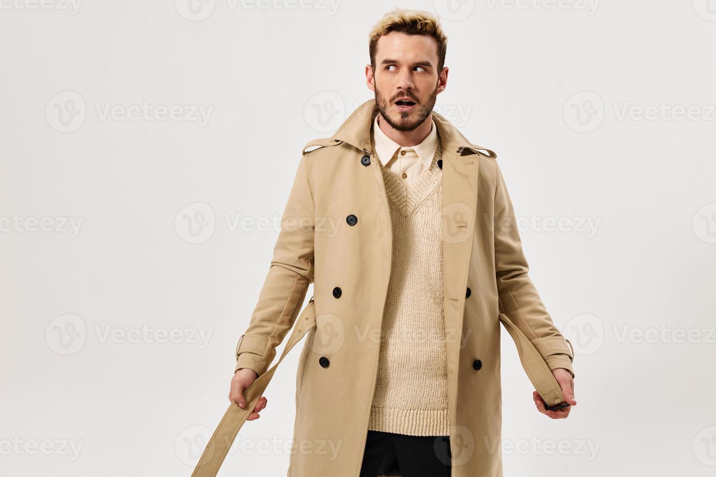 man with surprised expression beige coat autumn style side look photo