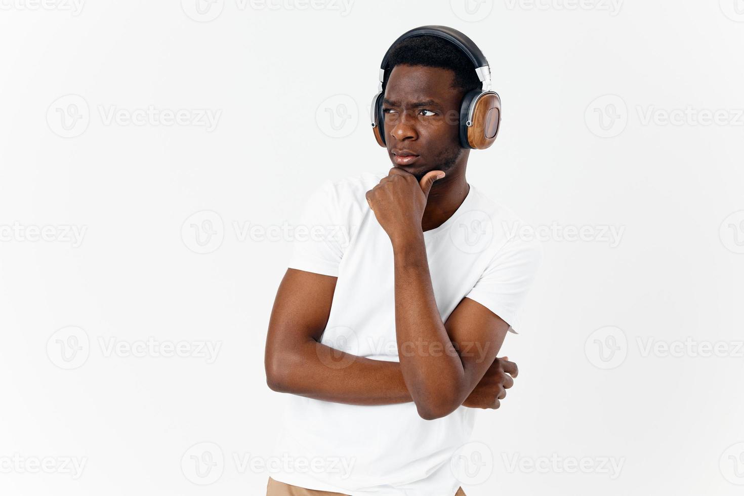 a man with a serious expression in headphones listening to music light background photo