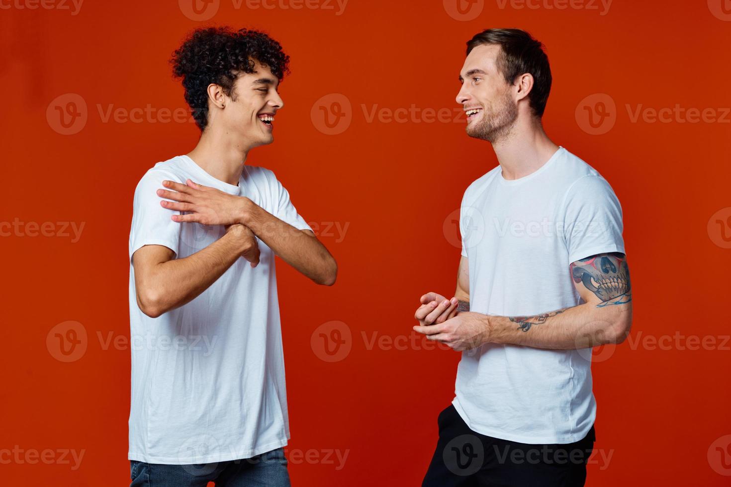 two men stand side by side fun friendship team red background photo