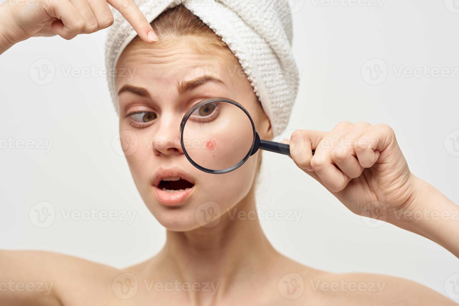 beautiful woman with a magnifying glass in hand skin problems photo