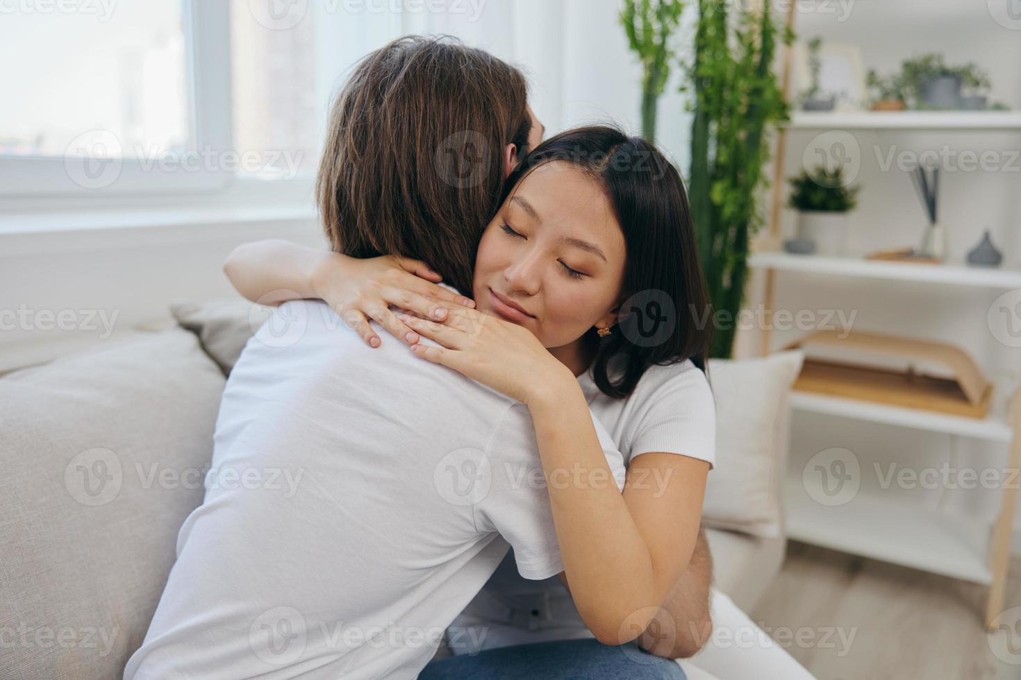 An Asian woman hugs her husband and smiles. The joy of using the family and the good psychological state after the quarrel photo