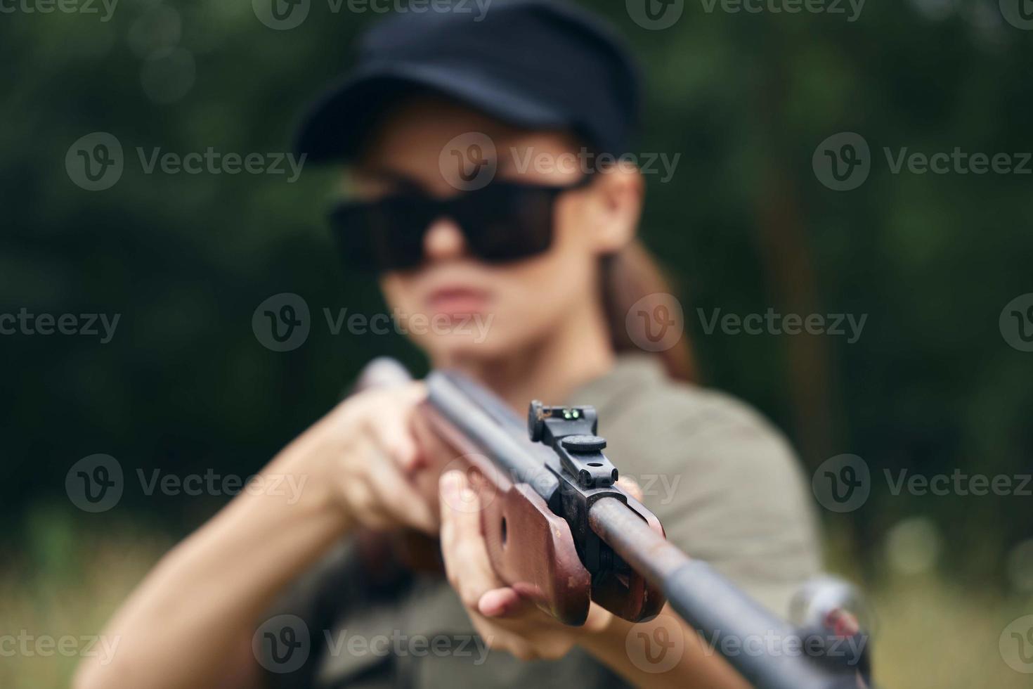 mujer escopeta en mano, vista, objetivo caza verde hojas foto
