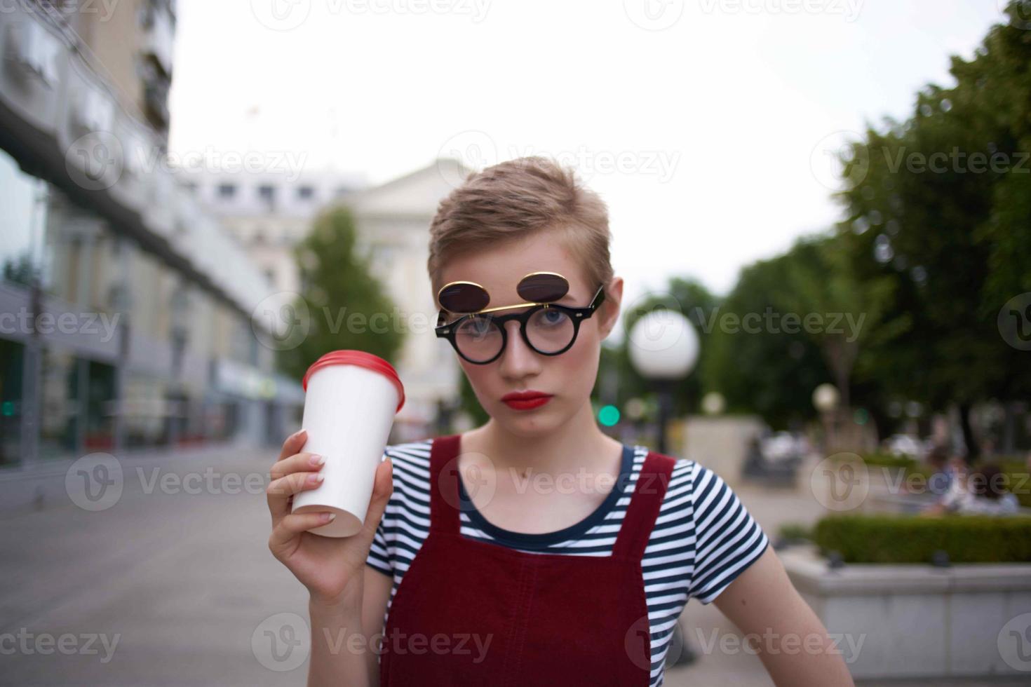 short haired woman wearing glasses walk glass with drink rest photo