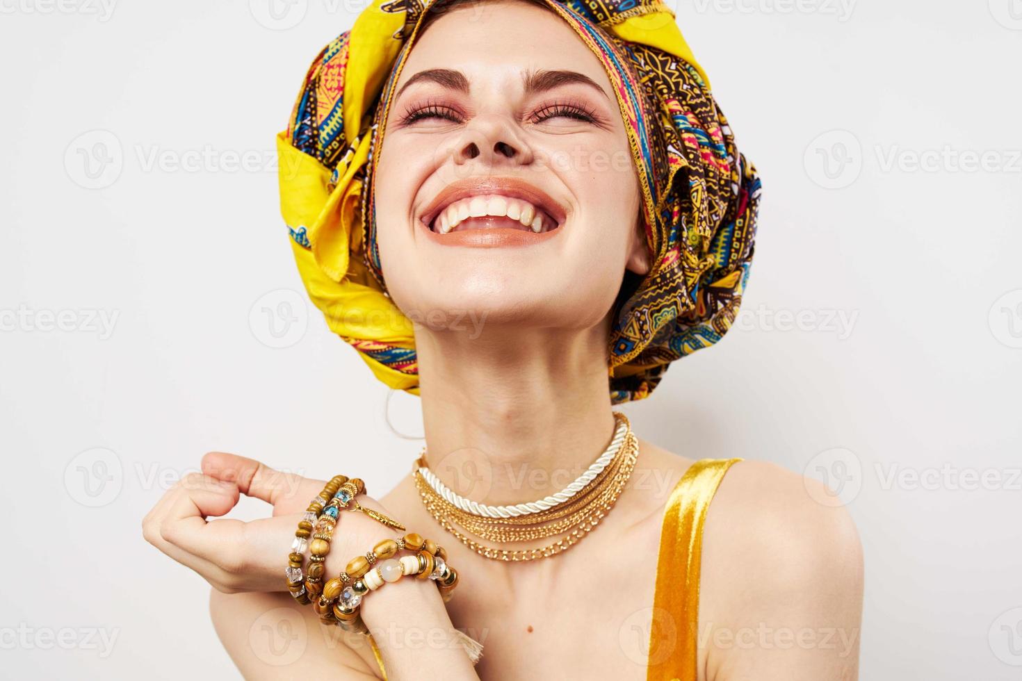 cheerful pretty woman in multicolored turban african style and fashion posing photo