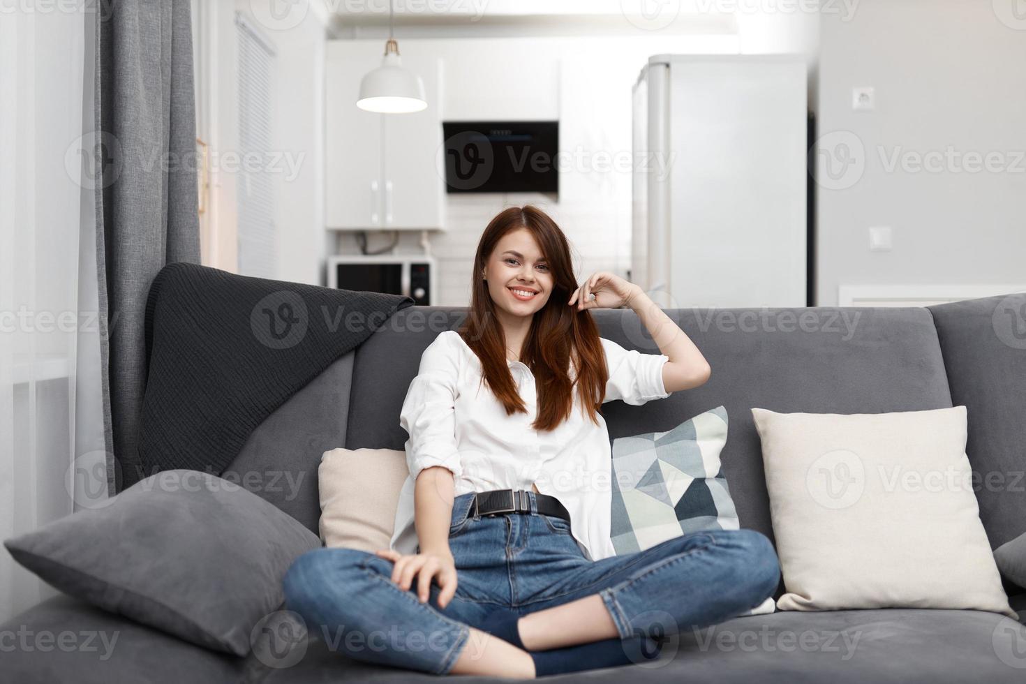 woman sitting on the couch leaning on the pillow at home photo