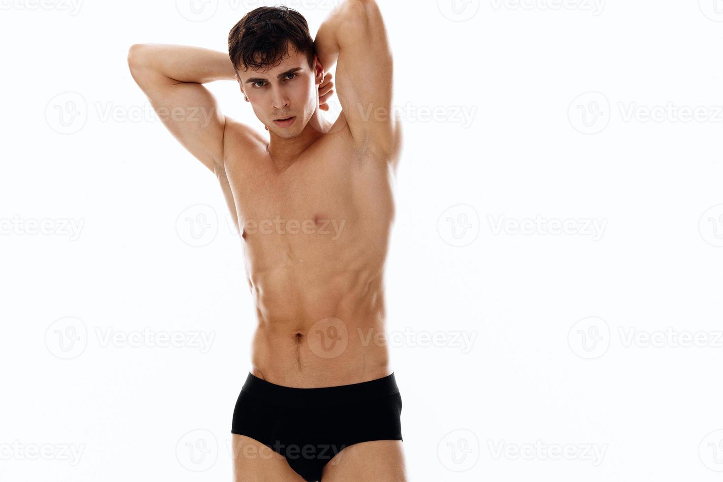 masculino atleta en negro pantalones cortos sostener manos detrás cabeza recortado ver foto