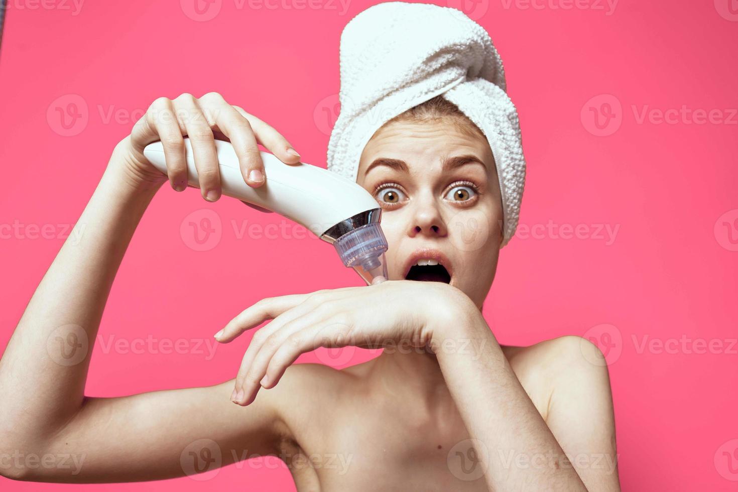 woman with bare shoulders with a towel on her head cleaning the skin photo
