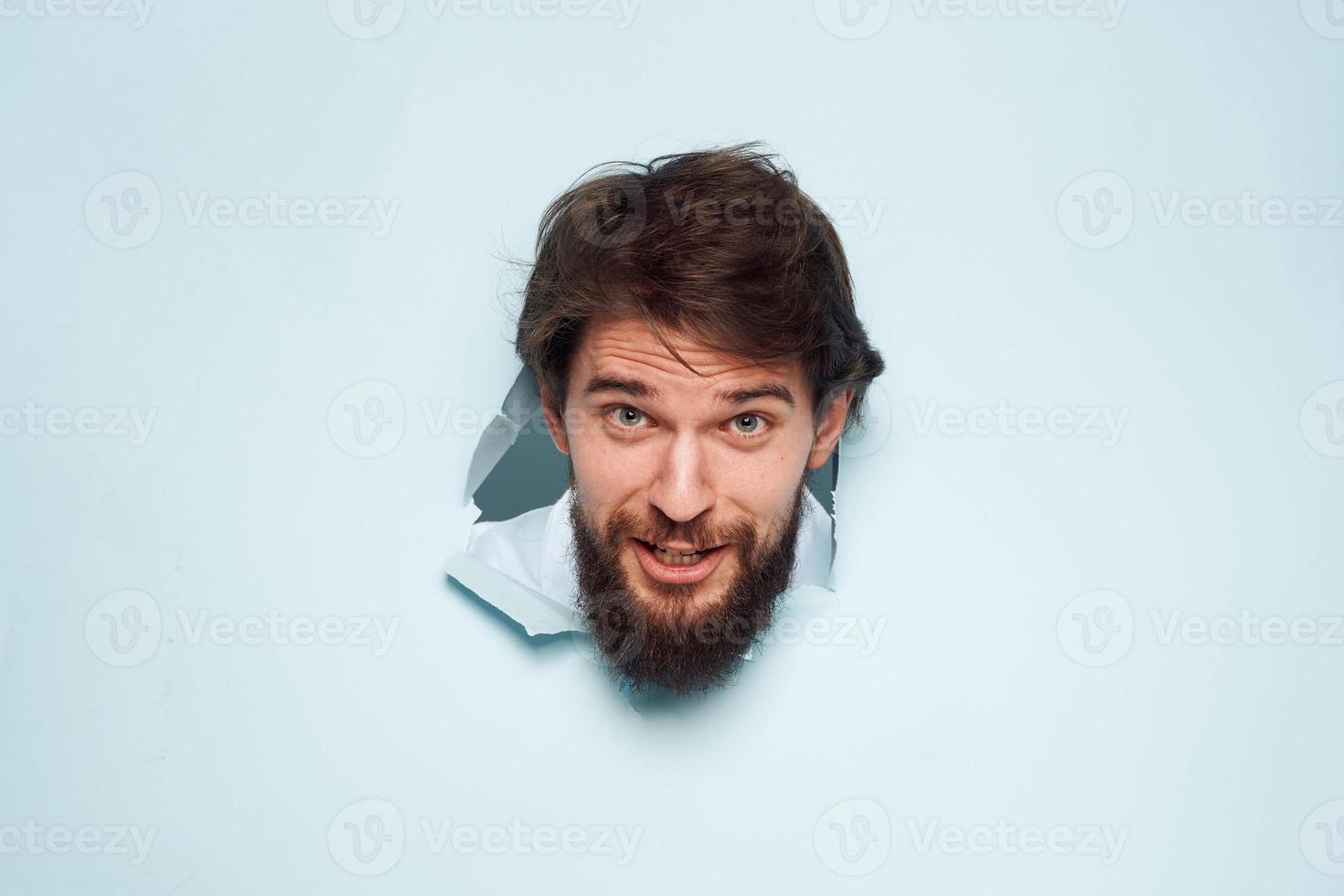 A bearded man peeps out from behind the wall dissatisfaction emotions office official photo