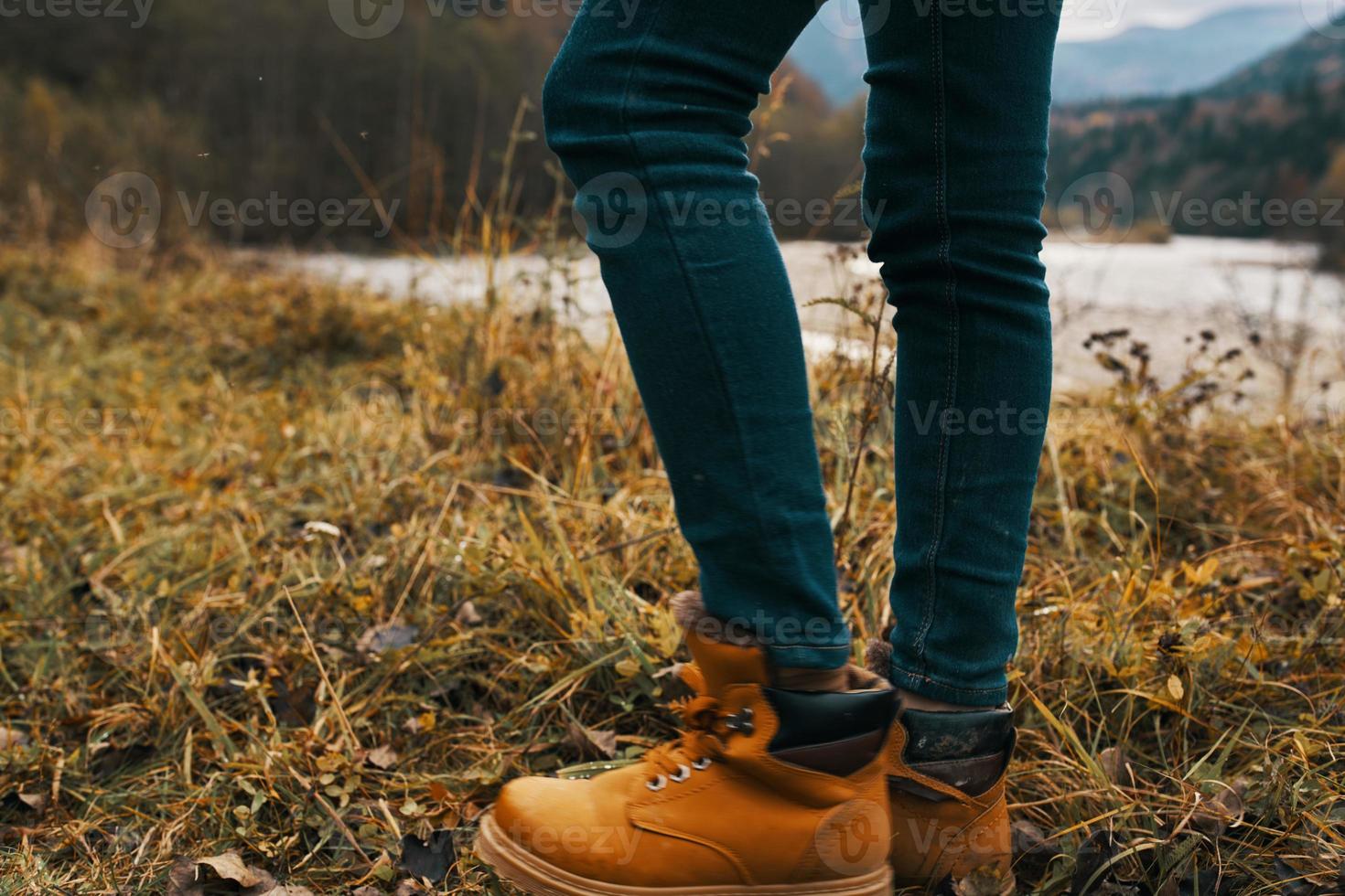 hembra piernas en botas y pantalones en naturaleza en otoño en el montañas foto