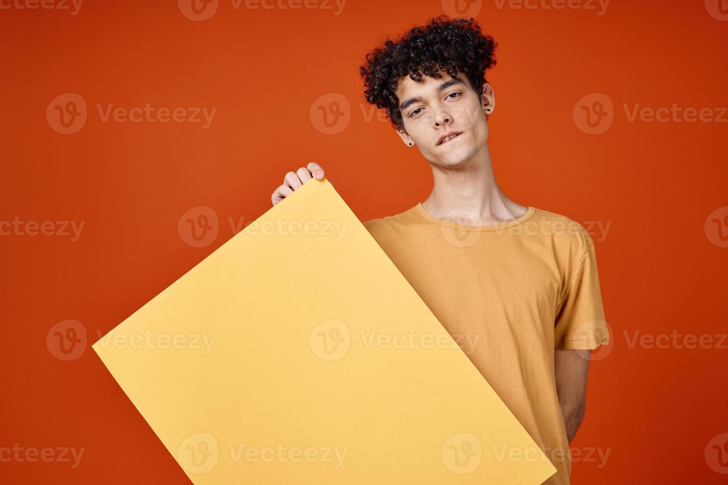 emotional guy with curly hair island in hands advertising red background photo
