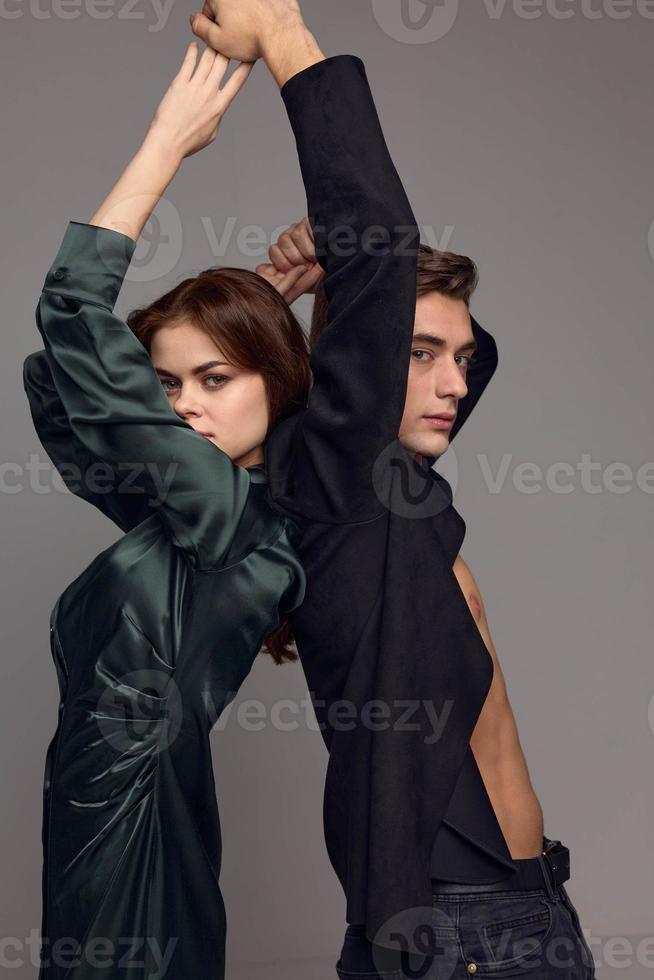 Cropped view of woman and man with hands raised up on gray background photo