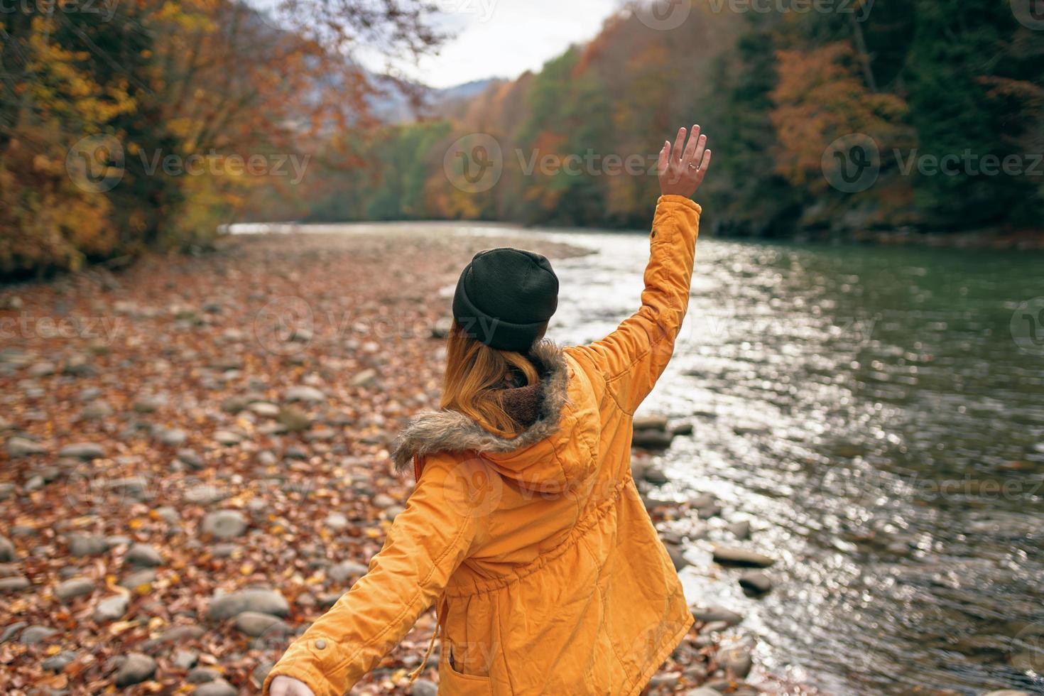 alegre mujer en naturaleza otoño bosque río libertad foto