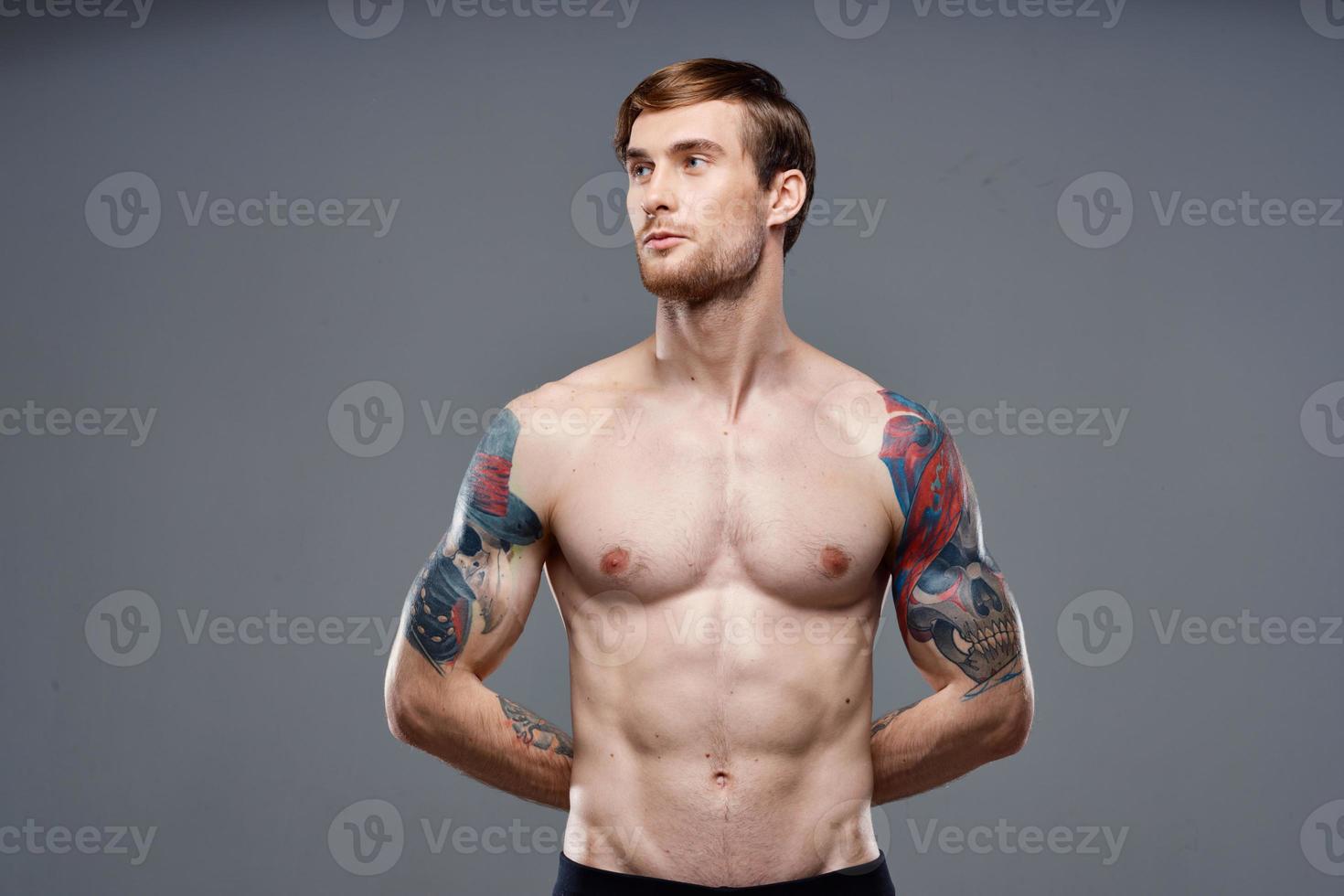 sport man cropped view workout tattoo on arms gray background photo