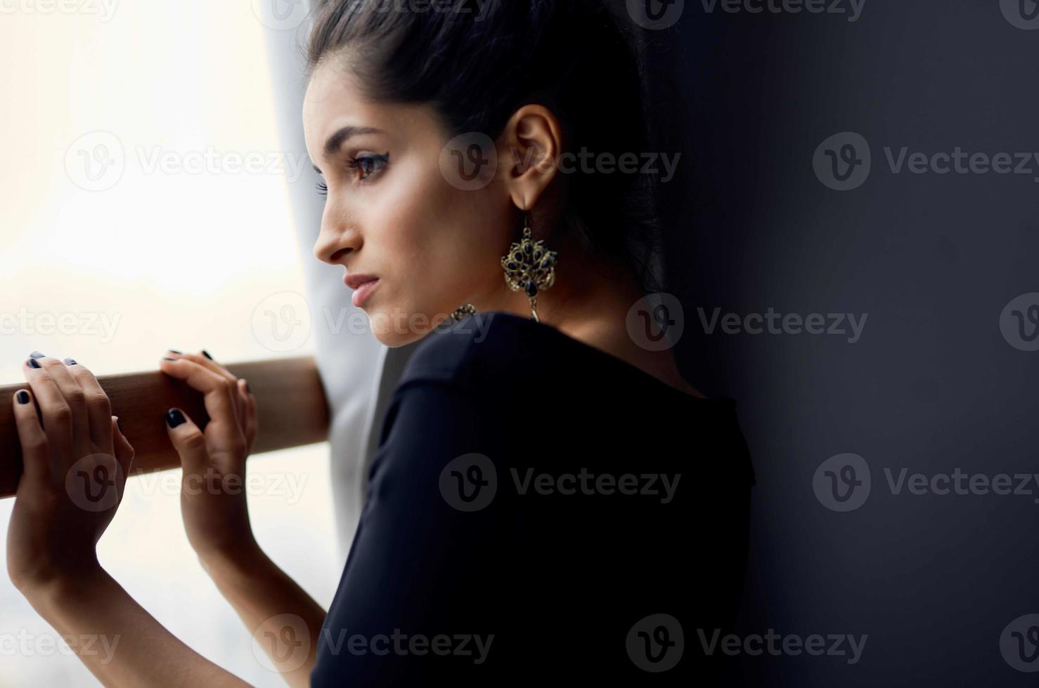 hermosa mujer cerca ventana posando atractivo Mira pendientes estilo de vida estudio foto