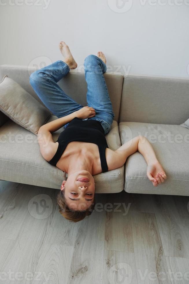 Young woman with short haircut hair having fun at home on the couch smile and happiness, vacation at home, natural posing without filters, free copy space photo