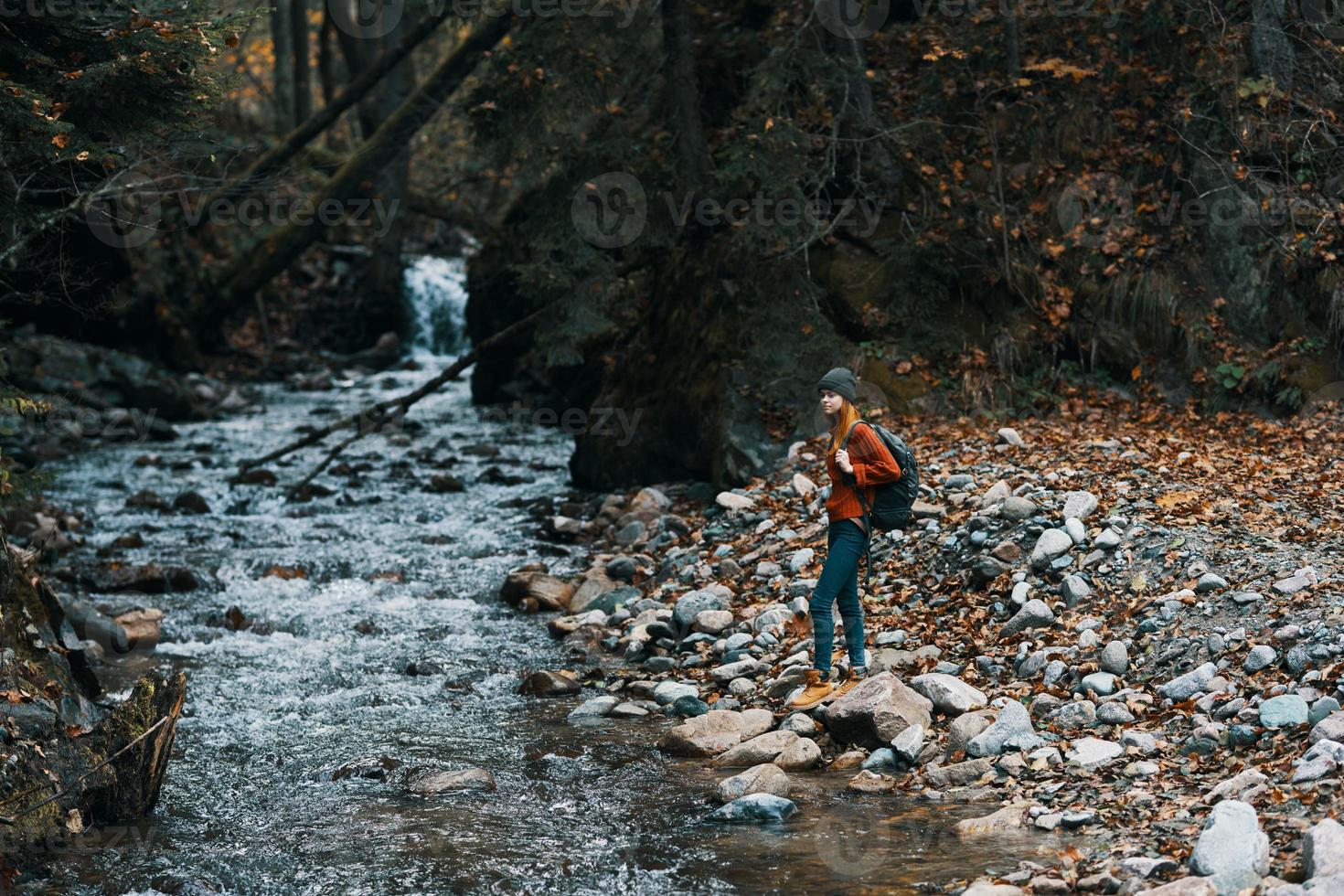 woman with backpack and autumn landscape mountains forest clear water river photo