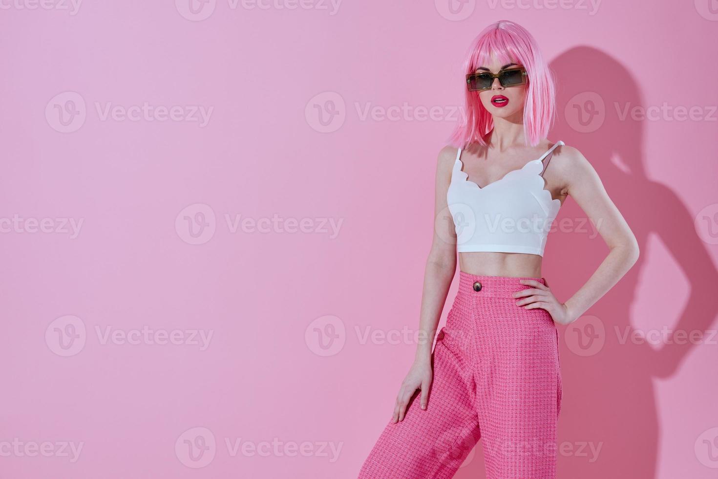 Pretty young female in pink pants sunglasses posing pink background unaltered photo